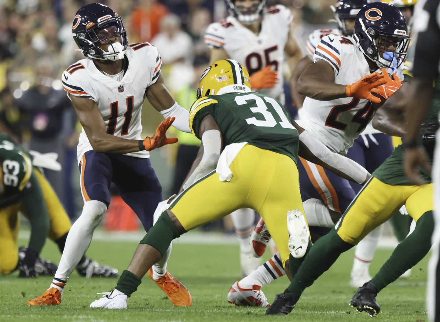 Bears wide receiver Darnell Mooney (11) blocks Packers safety Adrian Amos (31) as running back Khalil Herbert (24) rushes for a first down Sept. 18, 2022, at Lambeau Field in Green Bay.