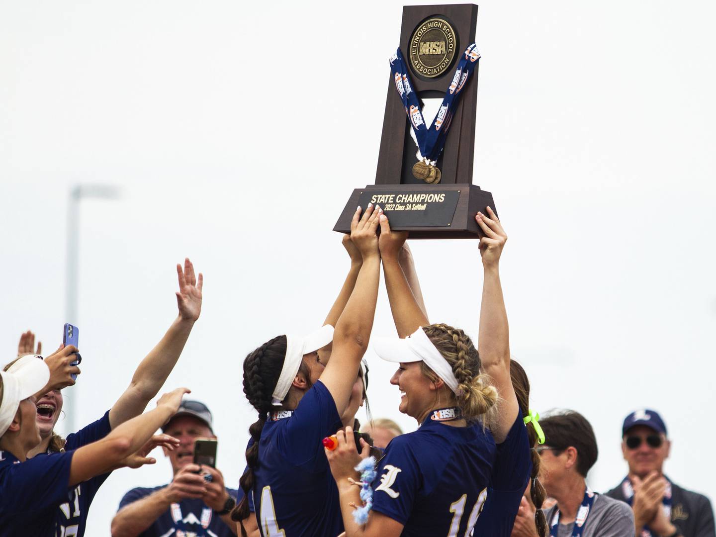 Lemont’s Sage Mardjetko, center, celebrates as her teammates hoist up the Class 3A state championship trophy on Saturday, June 11, 2022.