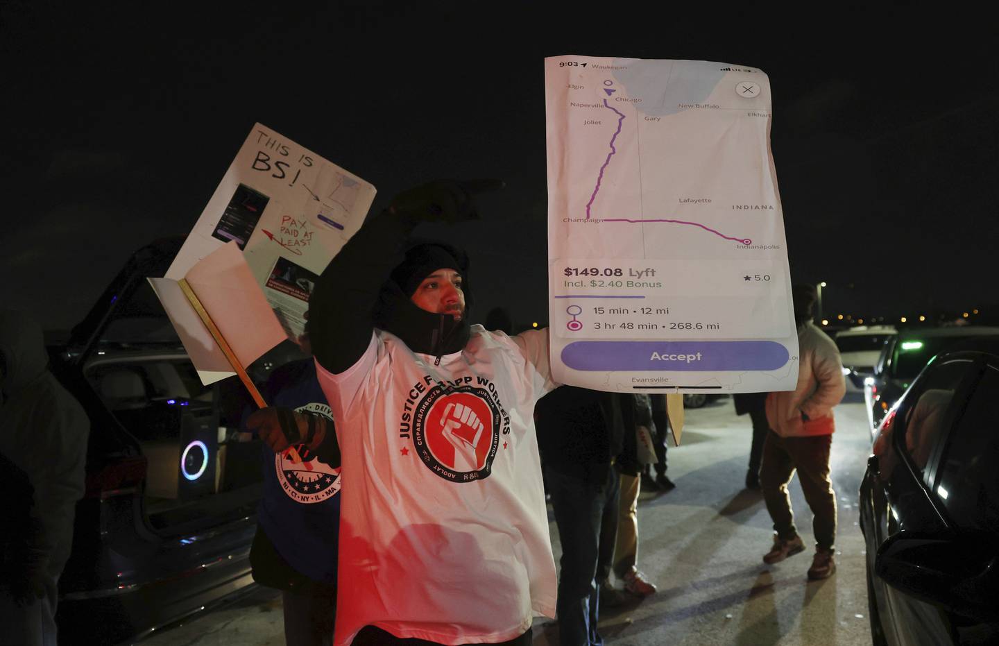 Wilman Irribarren holds up a printout of a ride-share drive made previously by an unknown driver, and the income earned for the drive, during a protest on Dec. 27, 2022.