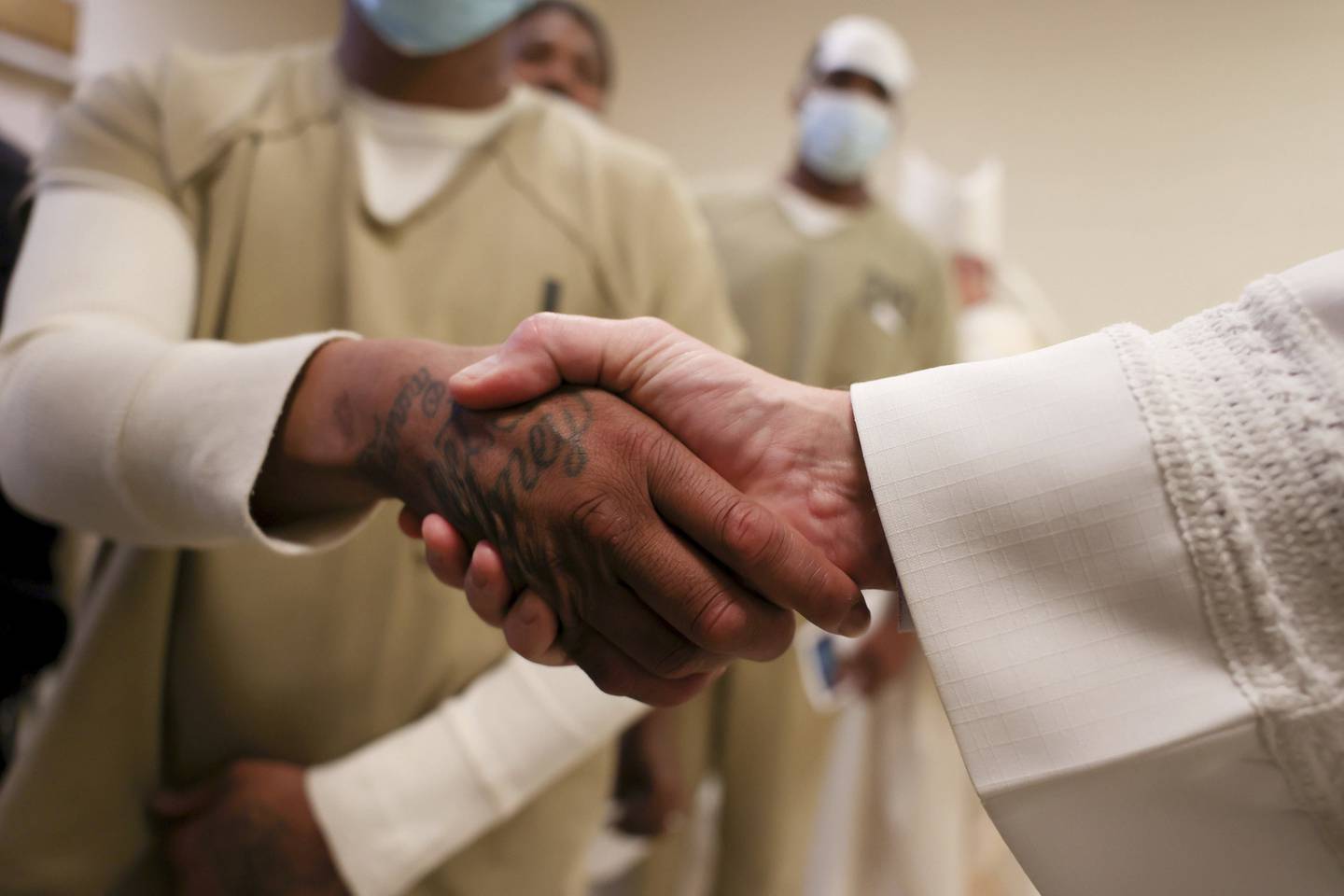 Deacon Tim McCormick shakes hands with men who are in custody at Cook County Jail. It was part of Cardinal Blase Cupich's annual Christmas Day visit to the jail. 