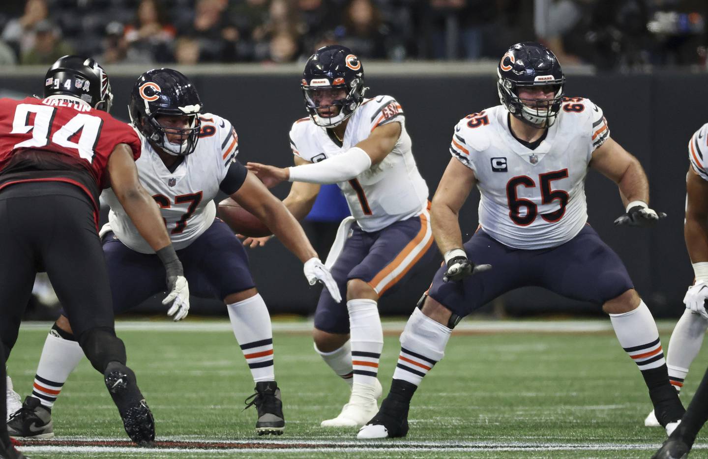 Bears offensive linemen Sam Mustipher (67) and Cody Whitehair (65) provide coverage for quarterback Justin Fields (1) in the second quarter against the Falcons at Mercedes-Benz Stadium on Nov. 20, 2022.