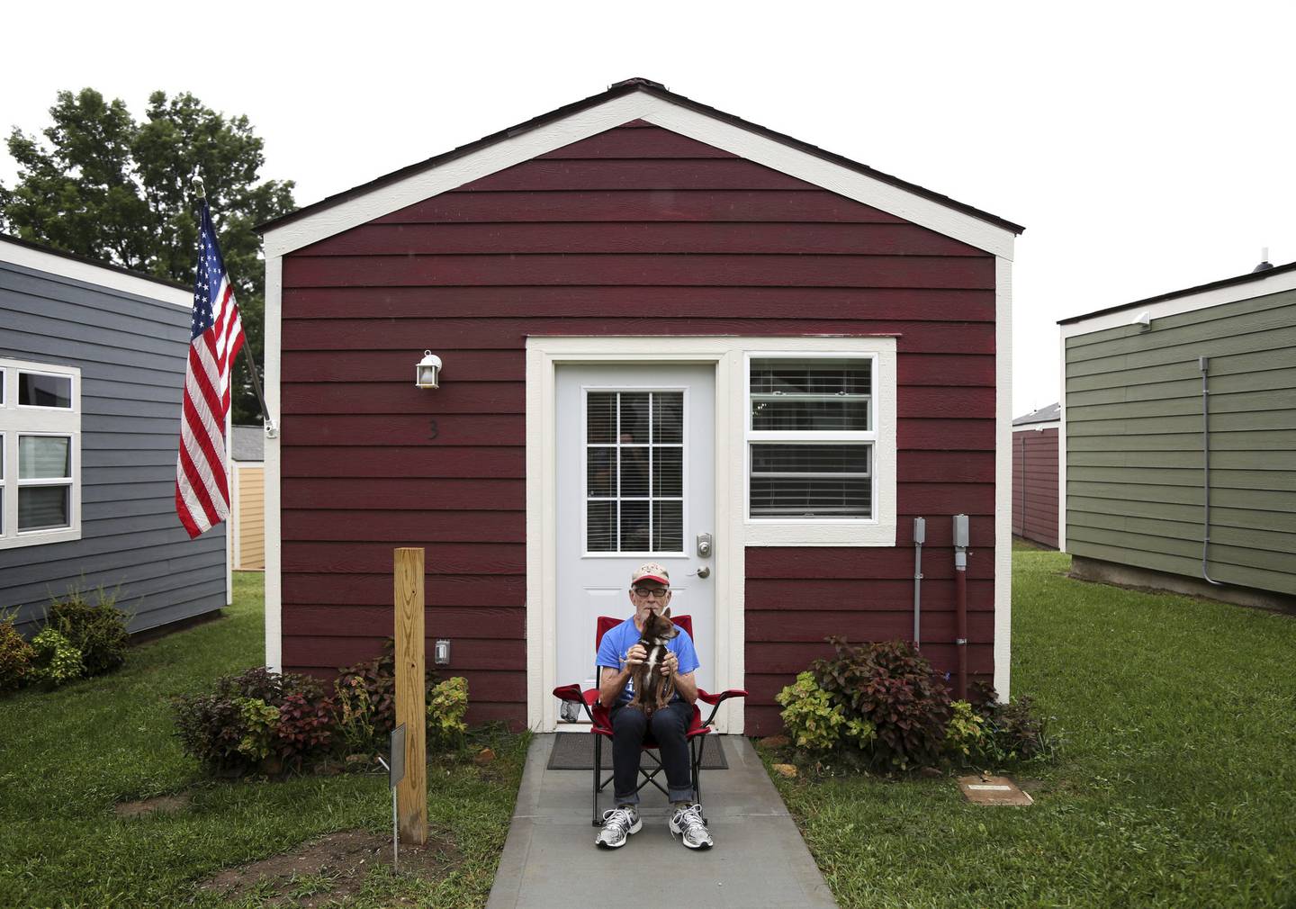 Leo Morris sits with his dog, Petey, in front his house in Kansas City, Missouri, in 2016. The project offers transitional housing to homeless veterans. Morris lost his house in a fire.