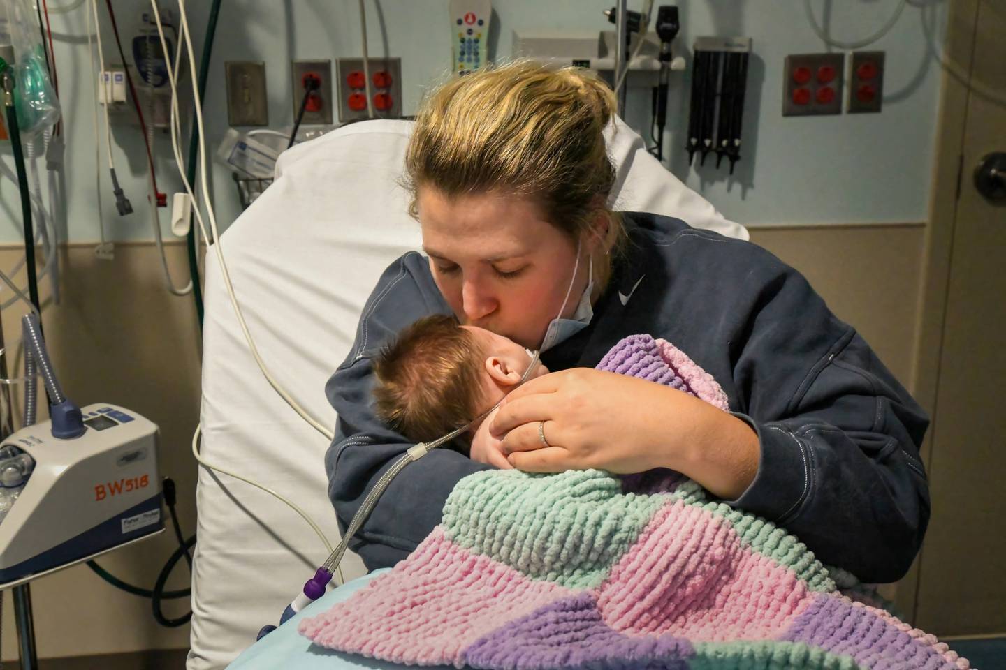 Caitlyn Houston kisses her infant daughter, Parker, as they wait in the emergency department for a hospital bed to open up at Corewell Health Helen DeVos Children's Hospital in Grand Rapids, Michigan, on Dec. 7, 2022.