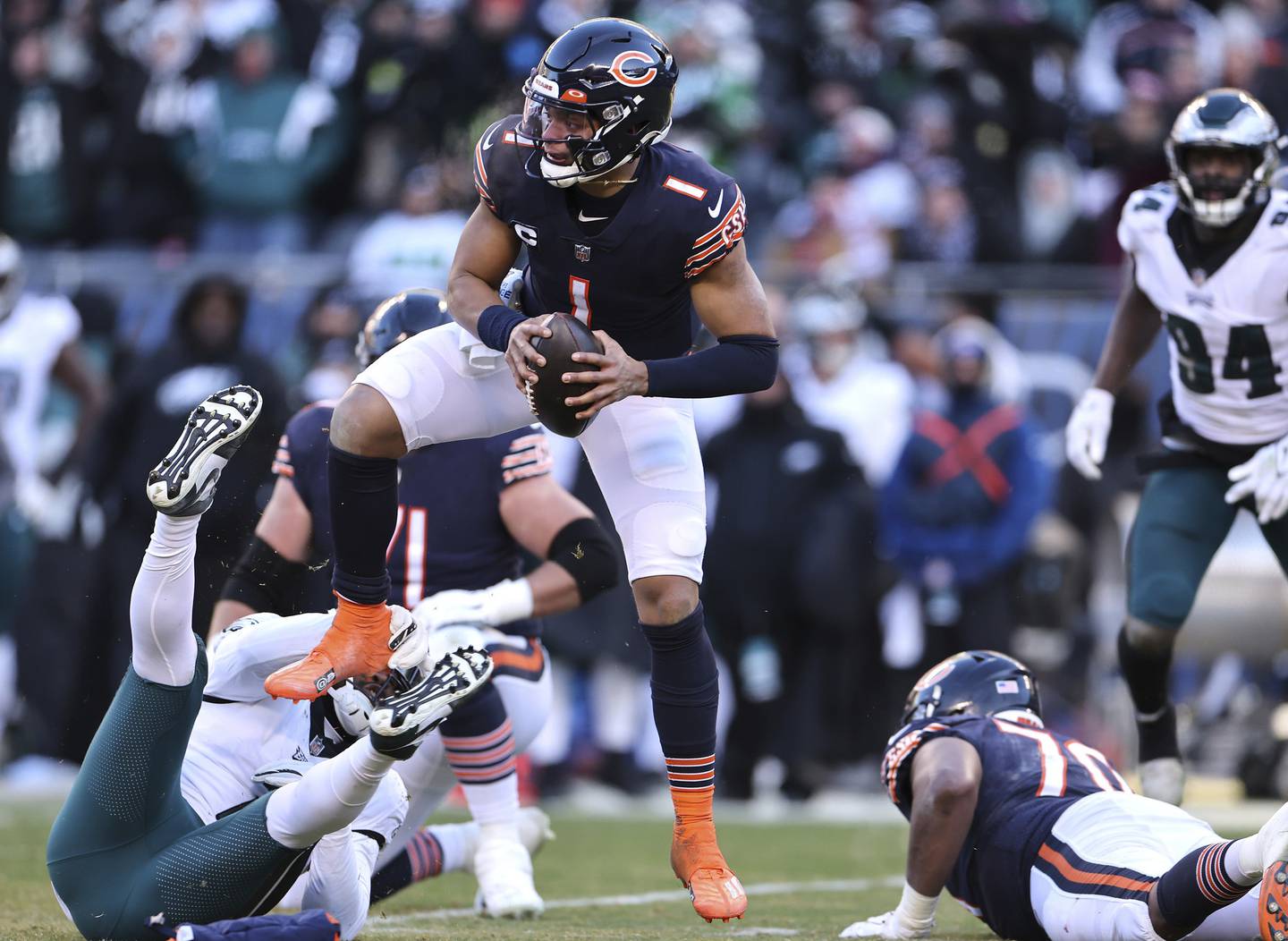 Bears quarterback Justin Fields (1) hops as he eludes the Eagles defense in the fourth quarter Sunday, Dec. 18, 2022, at Soldier Field. Fields briefly left the game after the play because of cramps.
