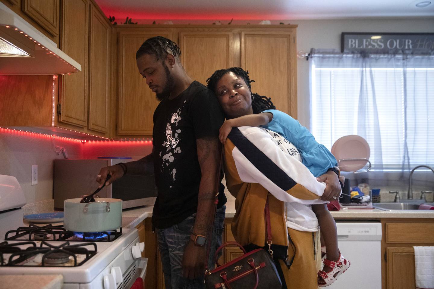 Sandra Brown holds her granddaughter Azariah Dobbs, 2, as her son Gregory Dobbs, 31, cooks at his home in Las Vegas on April 26, 2022. After spending 22 years in the Illinois prison system, this was Brown's first visit to Las Vegas and only the second time seeing her grandchildren outside prison walls. 