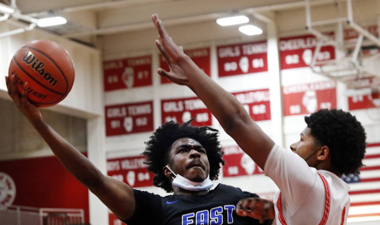 Lincoln-Way East's Tylon Toliver, left, tries to hook a shot over Homewood-Flossmoor's Jurrell Baldwin during a SouthWest Suburban Blue game on Friday, Feb. 11, 2022.