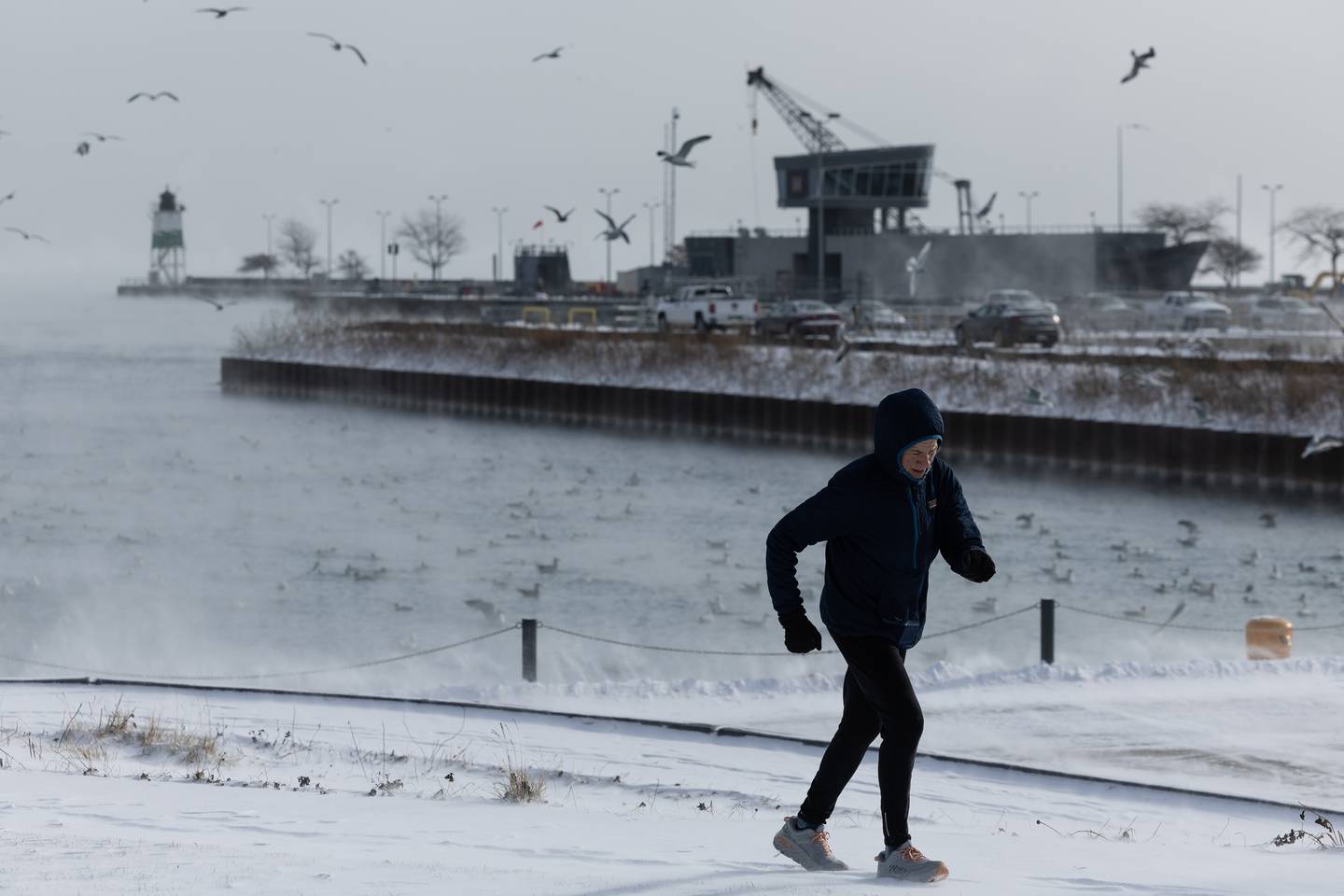 A runner jogs along the outer harbor near Navy Pier in below-freezing temperatures on Dec. 23, 2022.