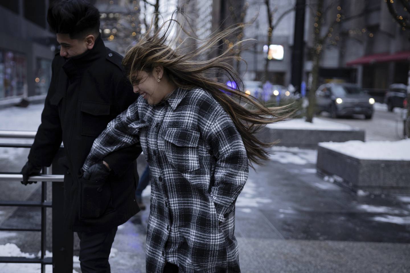 Leilany Mejia and Erik Roa hurry through the cold and wind for a date at the Signature Room  in Chicago on Dec. 23, 2022.
