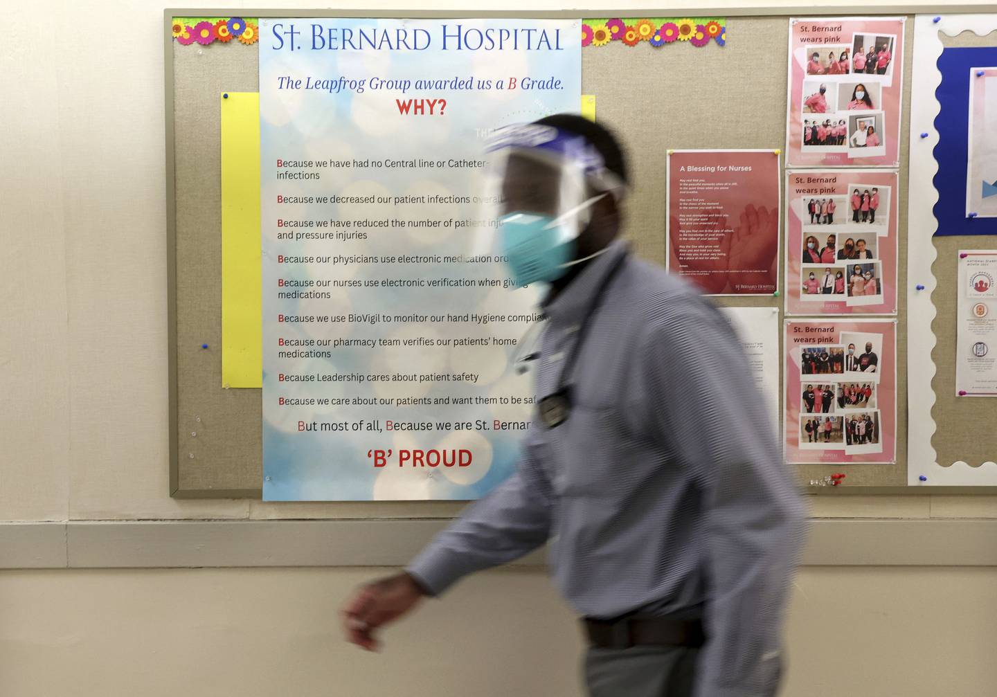 An employee passes a poster proudly announcing the “B” grade at St. Bernard Hospital in Chicago Nov.29, 2022. 
