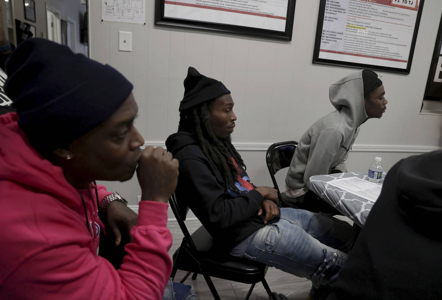 Outreach Specialist Cedric Hawkins, left, and new students Duane Taylor, center, and Perry Berry, right, listen during orientation at Youth Peace Center where Blackmon works as a mentor Nov. 17, 2022.