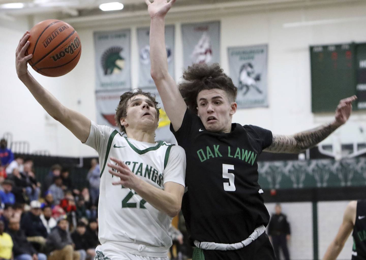 Evergreen Park's Nolan Sexton (22) drives to the basket as Oak Lawn's Robert Wagner (5) defends during a South Suburban Red game in Evergreen Park on Thursday, Dec. 8, 2022.
