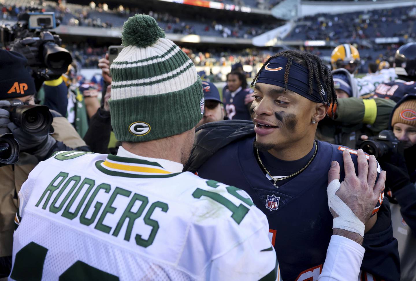 Packers quarterback Aaron Rodgers and Bears quarterback Justin Fields embrace after a Packers victory at Soldier Field on Dec. 4, 2022.