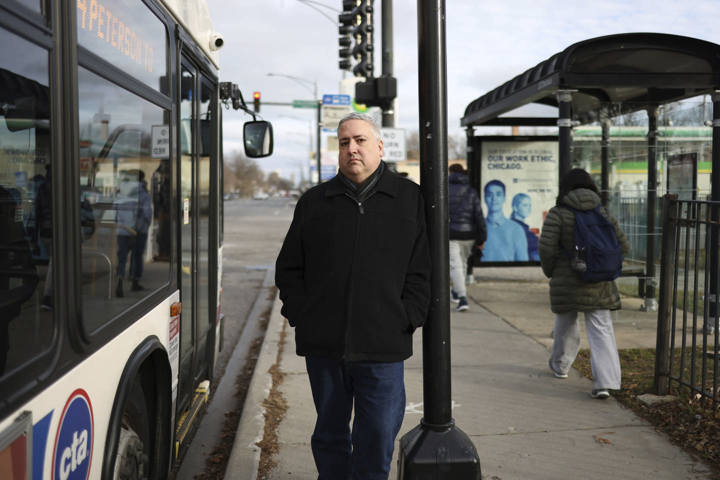Michael Doyle, of Chicago, at a bus stop across the street from his workplace in the 2800 block of West Peterson Avenue on Dec. 8, 2022, in Chicago. Doyle has decided to use ride-share services for now instead of using the CTA because of negative experiences, including having buses pass the stop while he waits.  