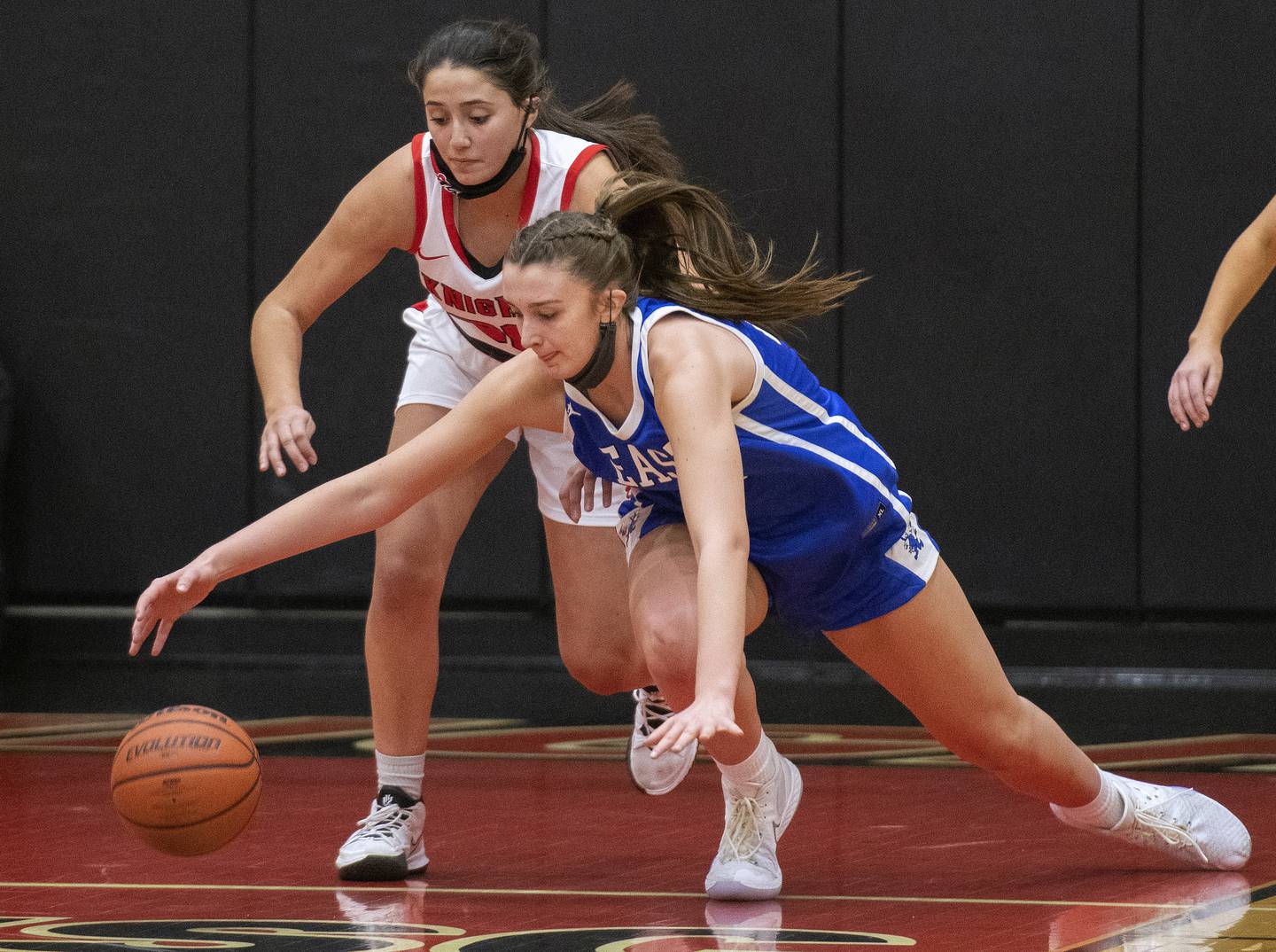 Lincoln-Way East's Hayven Smith lunges for a loose ball in front of Lincoln-Way Central's Angelina Panos during a game on Tuesday, Dec. 7, 2021.