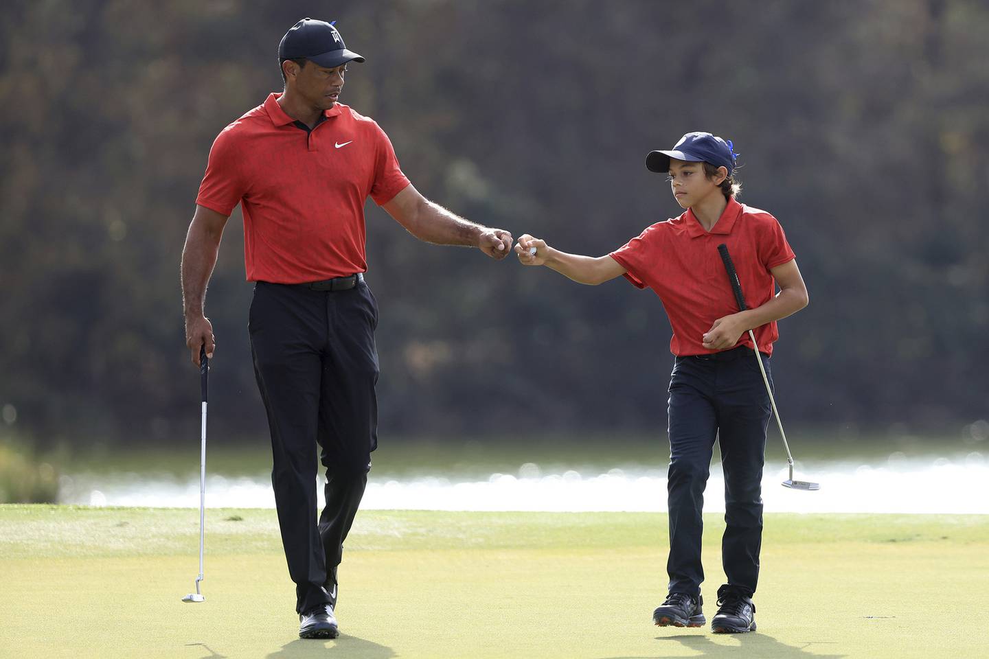 Tiger Woods and Charlie Woods celebrate a birdie on the 13th hole during the final round of the PNC Championship on Dec. 19, 2021, at the Ritz Carlton Golf Club Grande Lakes in Orlando, Fla.