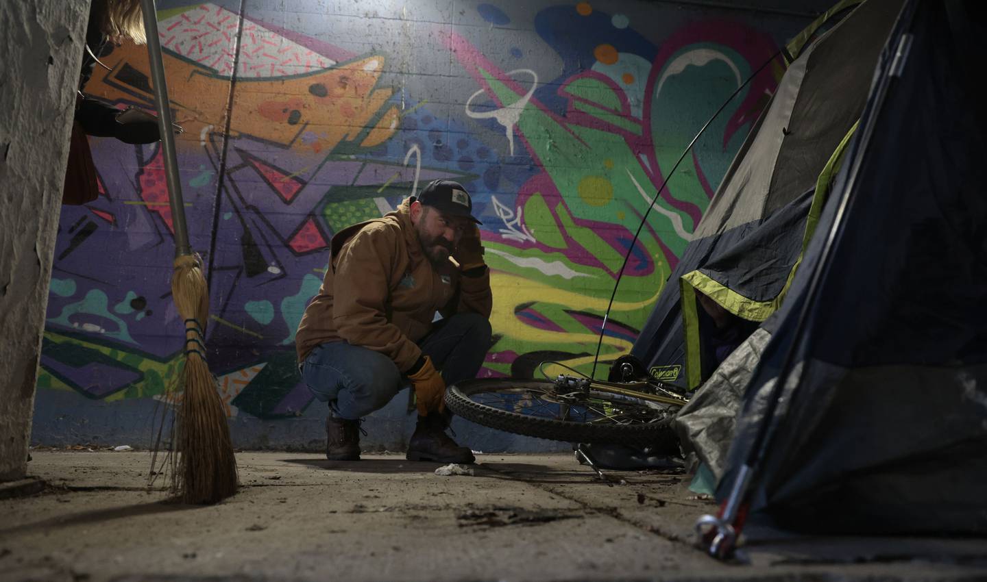 Andy Robledo, who has been building winterized tents for individuals experiencing homelessness around the city in the past year, speaks with a person under a viaduct at South Union Avenue and West 16th Street on Dec. 20, 2022.