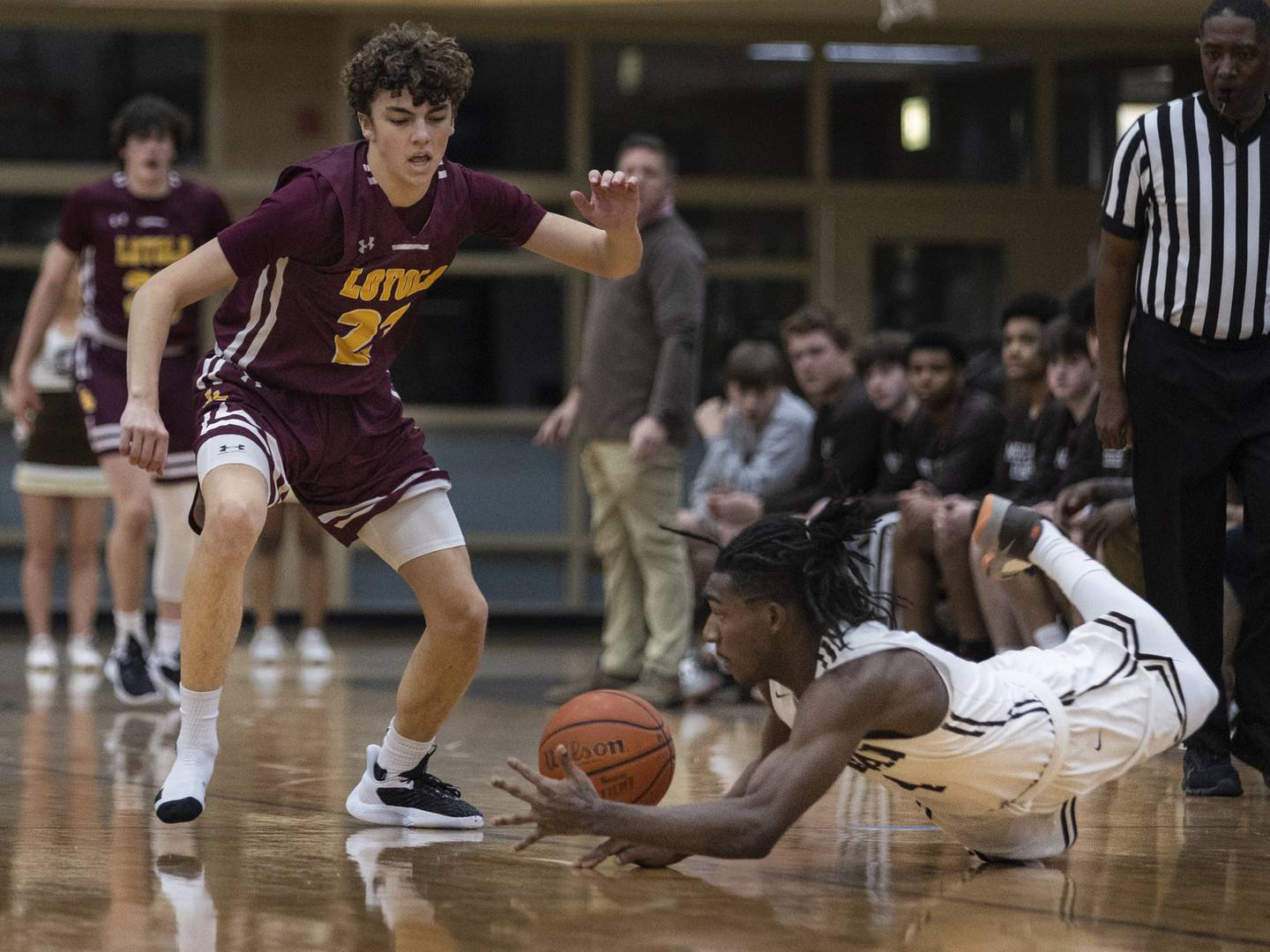 Mount Carmel's DeAndre Craig (4) dives for a loose ball against Loyola during a Catholic League Blue game in Chicago on Tuesday, Dec. 20, 2022.