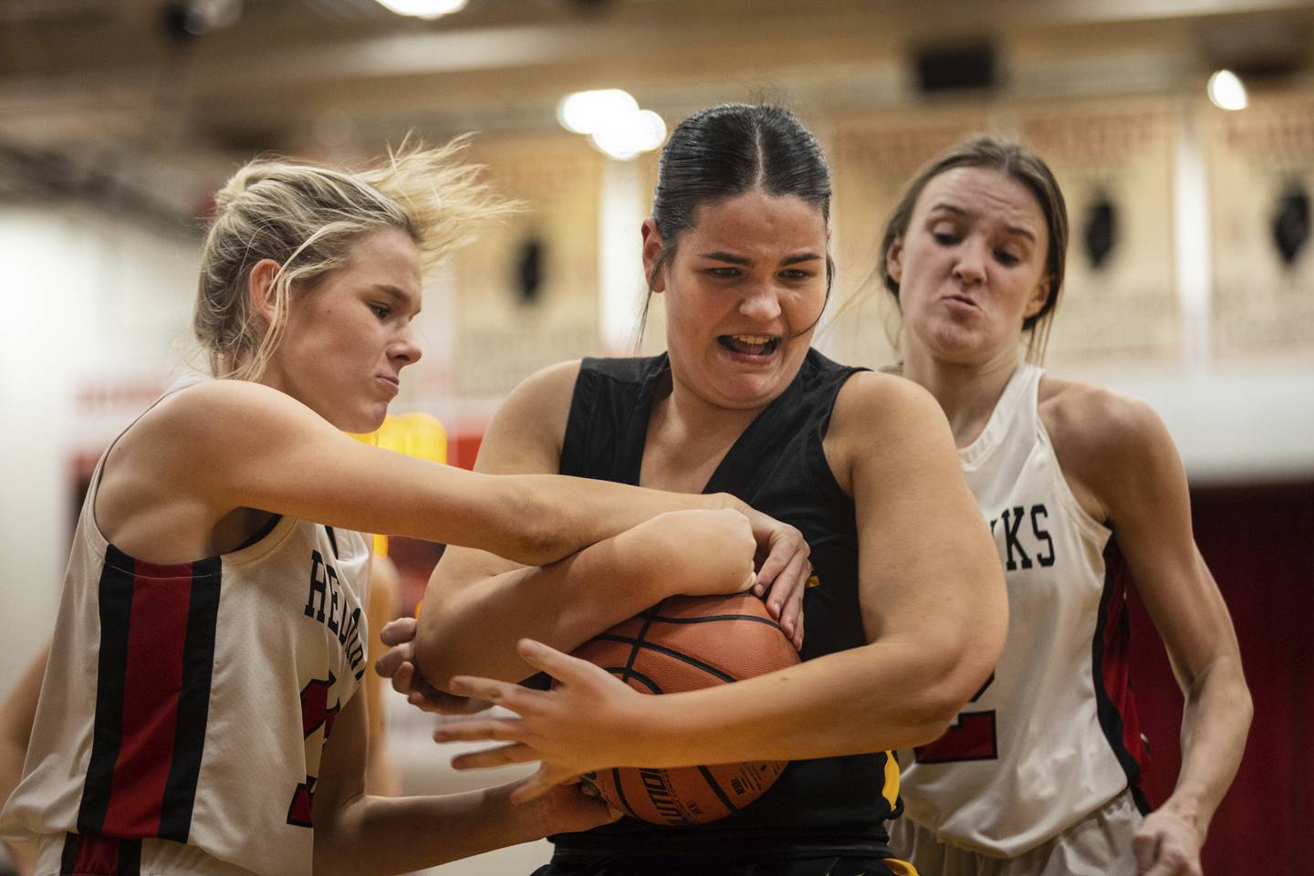 Marist’s Elizabeth Badke, left and Elise Ward try to wrestle the ball away from St. Laurence's Hannah Cholke during a nonconference game in Chicago on Monday, Dec. 19, 2022.