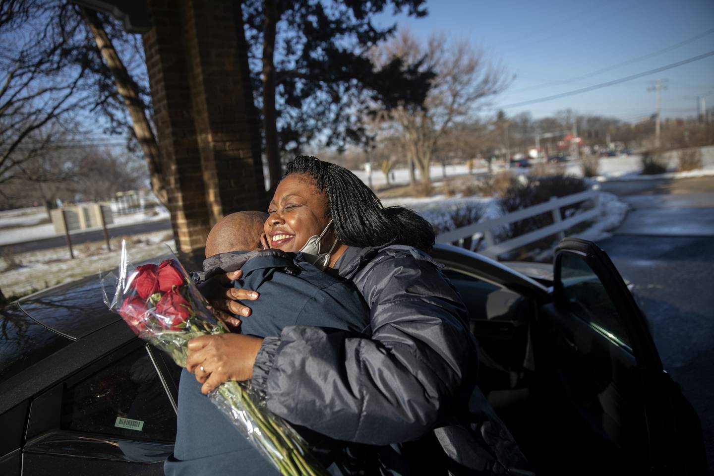 Sandra hugs her husband, Arnold Bass, who brought flowers for her, as she leaves Fox Valley Adult Transition Center on Jan. 13, 2022. Sandra met Arnold through a prisoner correspondence website. The two eventually fell in love through letters and married in 2018 while Sandra was still incarcerated.