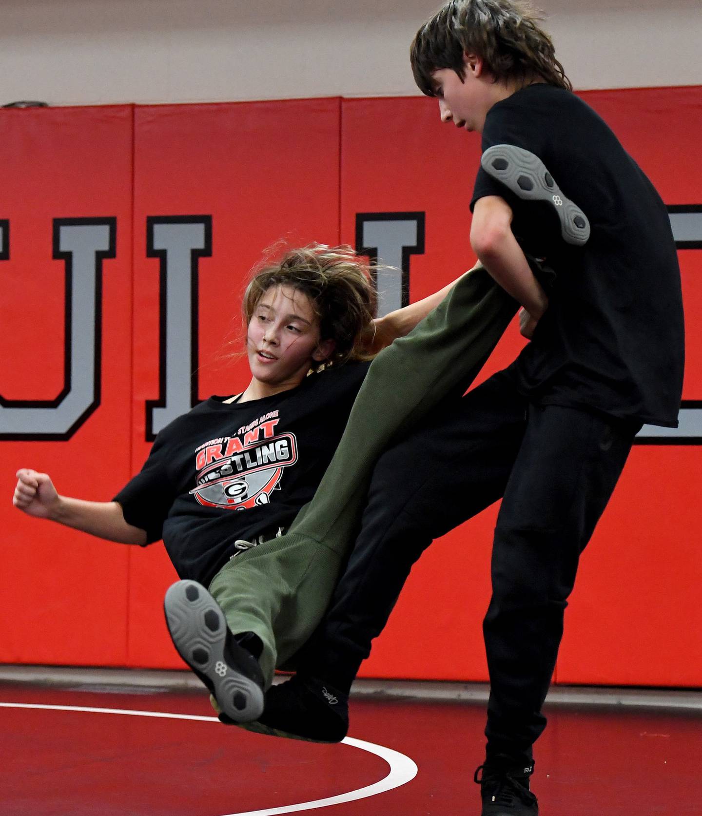 Vince Jasinski, right, takes down his sister, Ayane, during a practice on campus on Monday, Dec. 5, 2022.