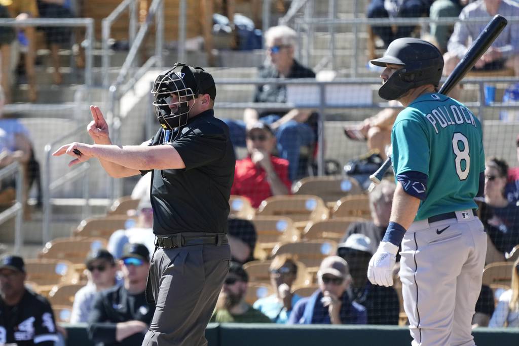Plate umpire Paul Clemons, left, calls a pitch-clock violation against White Sox reliever Reynaldo Lopez as the Mariners' AJ Pollock looks on during a spring training game on Feb. 27 in Phoenix. 