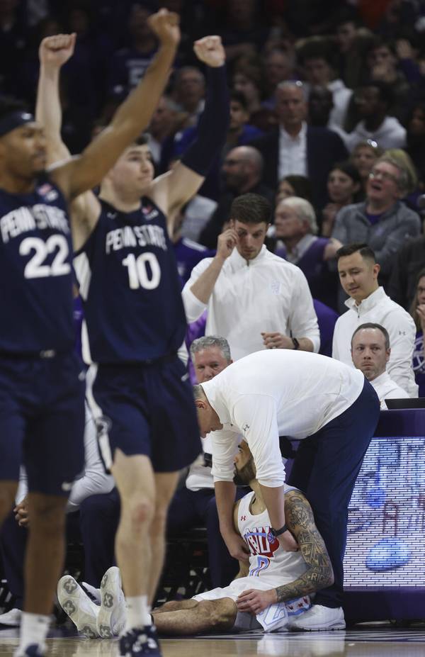 Penn State guards Jalen Pickett (22) and Andrew Funk (10) celebrate their victory as Northwestern coach Chris Collins consoles guard Boo Buie after Buie missed a last-second heave in overtime Wednesday, March 1, 2023, at Welsh-Ryan Arena in Evanston.