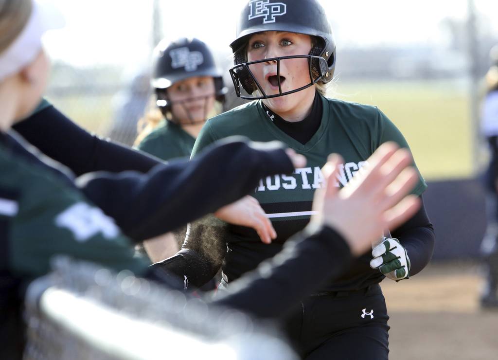 Evergreen Park's Maggie Tracy celebrates sliding safely into home against Reavis during a South Suburban Red game in Burbank on Tuesday, March 28, 2023.