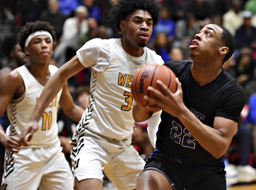 Lincoln-Way East's Kyle Olagbegi (22) goes to the basket in front of Joliet West's Matthew Moore (3) and Jeremy Fears during a Class 4A Bolingbrook Sectional semifinal game on Tuesday, Feb. 28, 2023.