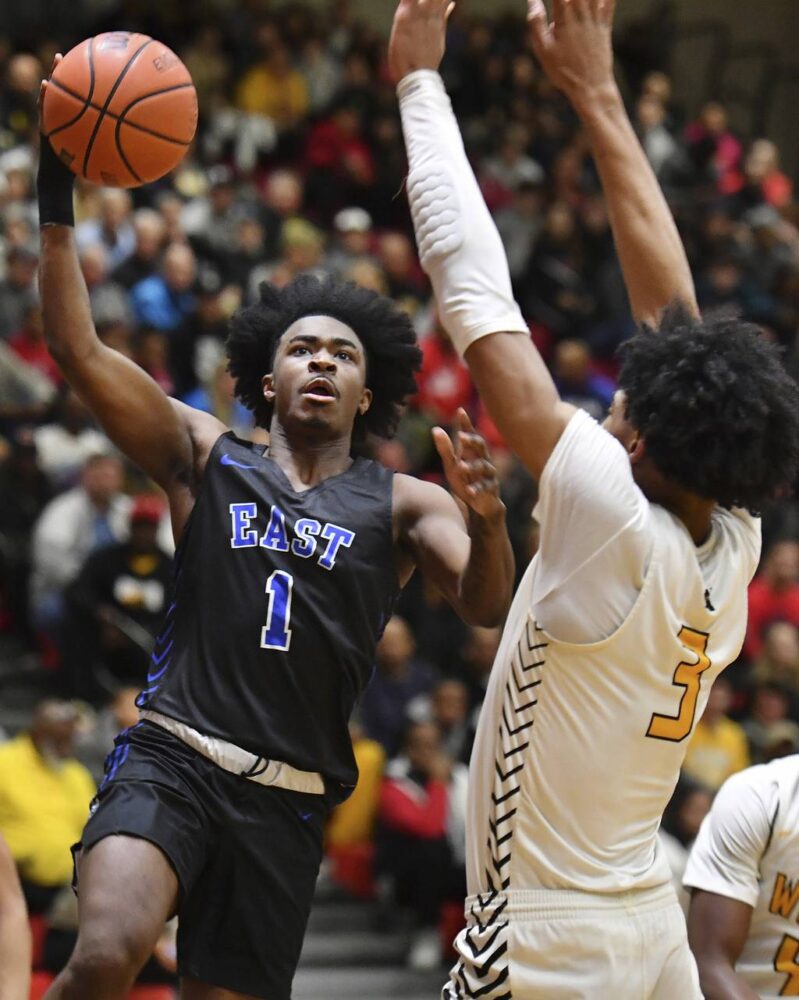 Lincoln-Way East's Tylon Tolliver (1) goes up over Joliet West's Matthew Moore during a Class 4A Bolingbrook Sectional semifinal game on Tuesday, Feb. 28, 2023.