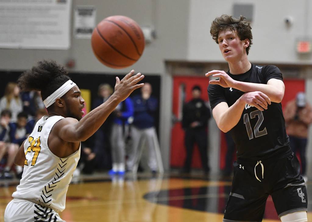 Oswego East's Ryan Johnson (12) fires a pass past Joliet West's Jayden Martin during the Class 4A Bolingbrook Sectional championship game on Friday, March 3, 2023.