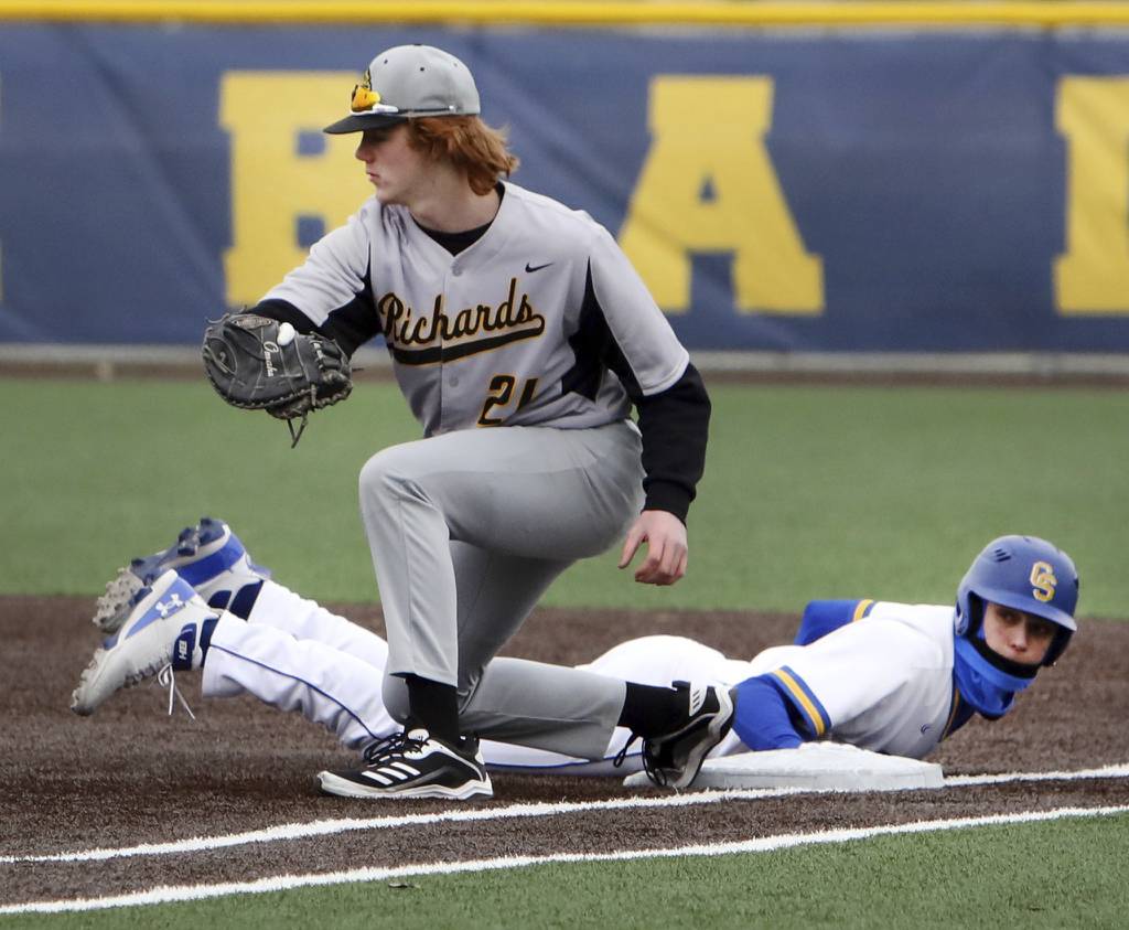 Richards' Neil Glynn covers first base as Sandburg's Jason Sullivan slides back safely during a nonconference game in Orland Park on Friday, March 24, 2023.