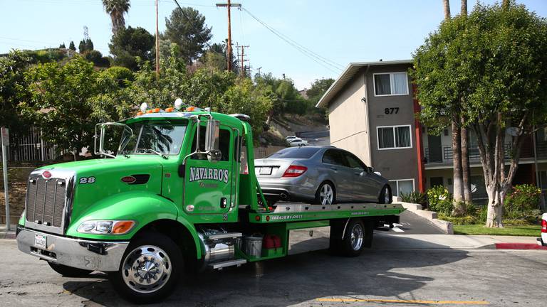 A tow truck hauls away the Mercedes-Benz where Saieed Ivey was found slain in the early morning hours of June 9, 2016, in Monterey Park, California.