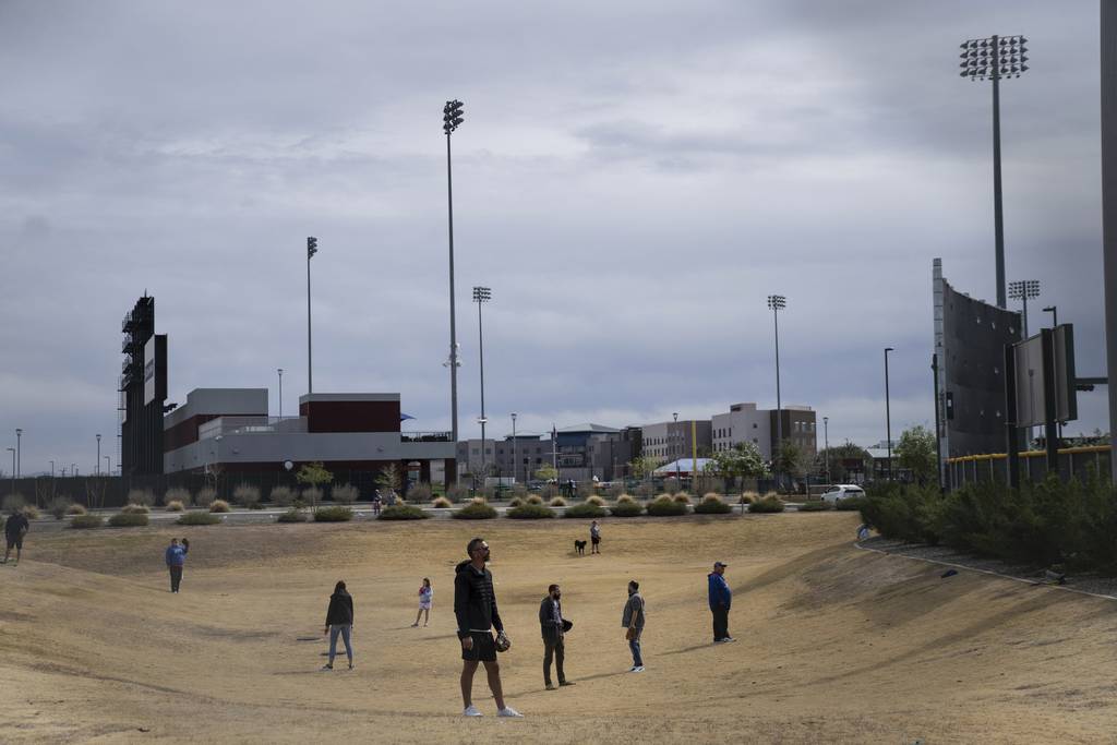 Ballhawks prowl the desert behind a practice field at Sloan Field in Mesa, Arizona, Saturday, Feb. 25, 2023.   (E. Jason Wambsgans/Chicago Tribune)