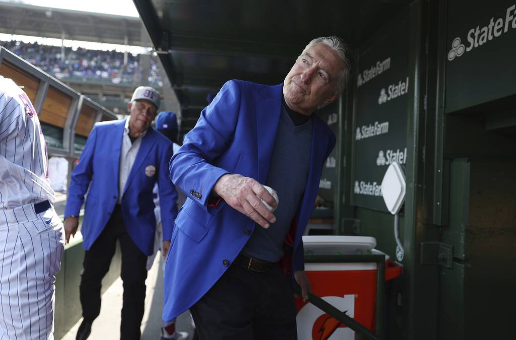 Cubs radio play-by-play broadcaster Pat Hughes walks through the dugout Thursday after throwing the ceremonial first pitch on opening day before a game against the Brewers at Wrigley Field.