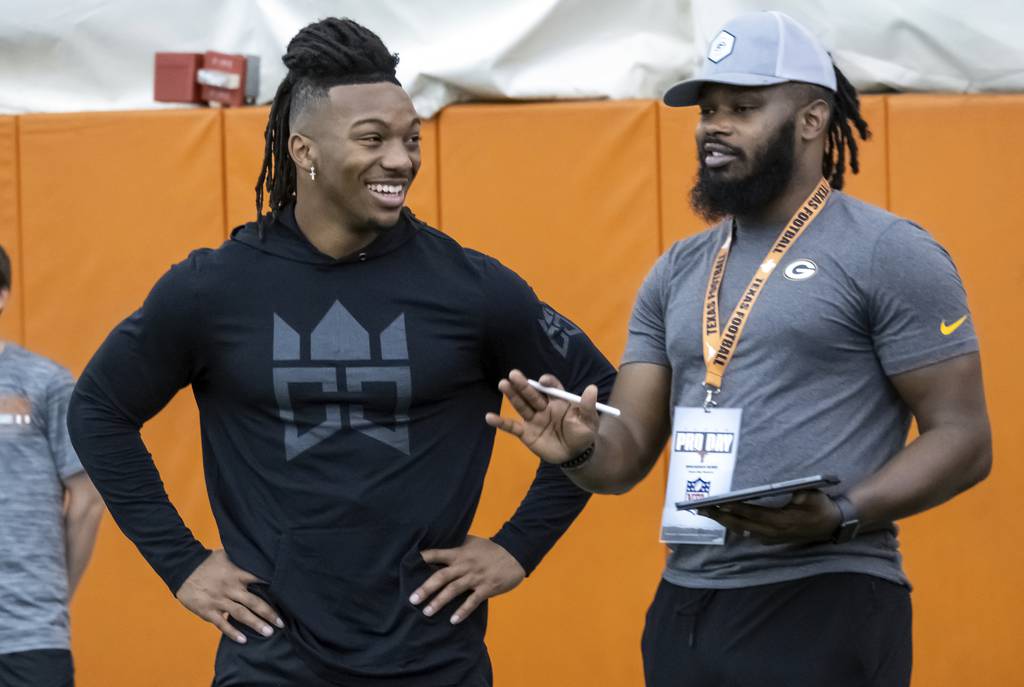 Texas running back Bijan Robinson, left, speaks with Packers scout Brandian Ross during Texas pro day on March 9, 2023, in Austin, Texas.