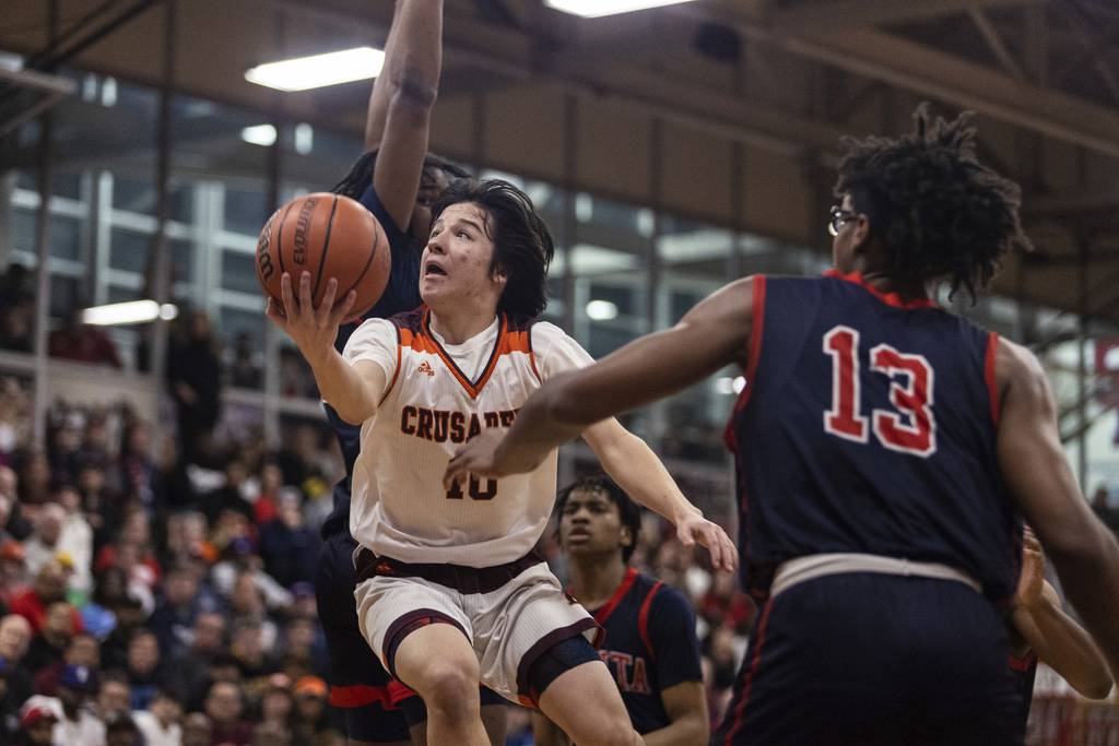 Brother Rice's Cale Cosme (10) splits a pair of St. Rita players on a layup in the first half during a Class 4A St. Rita Sectional semifinal in Chicago on Wednesday, March 1, 2023.