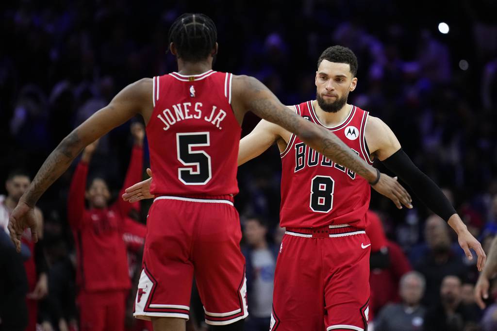 Zach LaVine and Derrick Jones Jr. celebrate during double overtime against the 76ers on March 20, 2023.