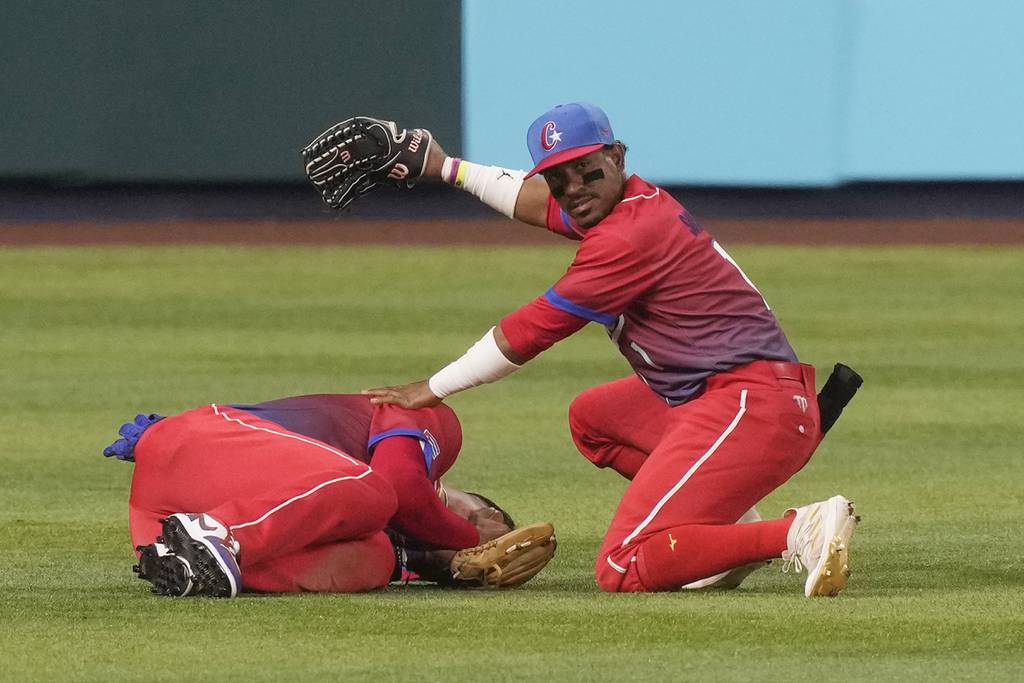 Cuba left fielder Roel Santos (1) calls for help after third baseman Yoán Moncada was injured after a collision during a World Baseball Classic semifinal against Team USA on Sunday in Miami.