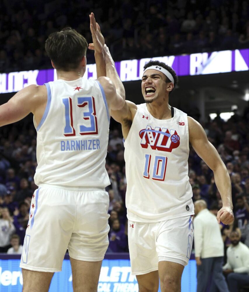 Northwestern guard Brooks Barnhizer (13) and forward Tydus Verhoeven (10) celebrate a big block by Verhoeven in overtime on March 1, 2023, at Welsh-Ryan Arena in Evanston.