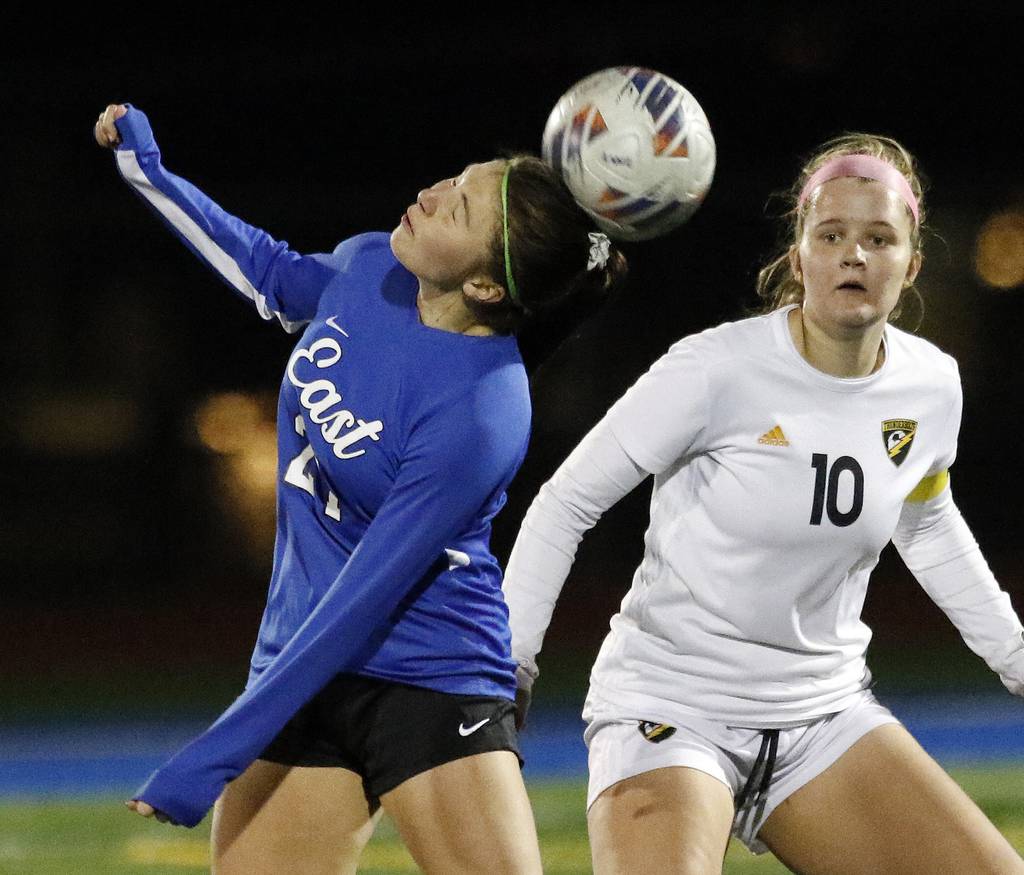 Lincoln-Way East's Madison Dziedzic (21) heads the ball as Andrew's Jessica Morawski (10) converges during a SouthWest Suburban Conference crossover in Frankfort on Tuesday, March 28, 2023.