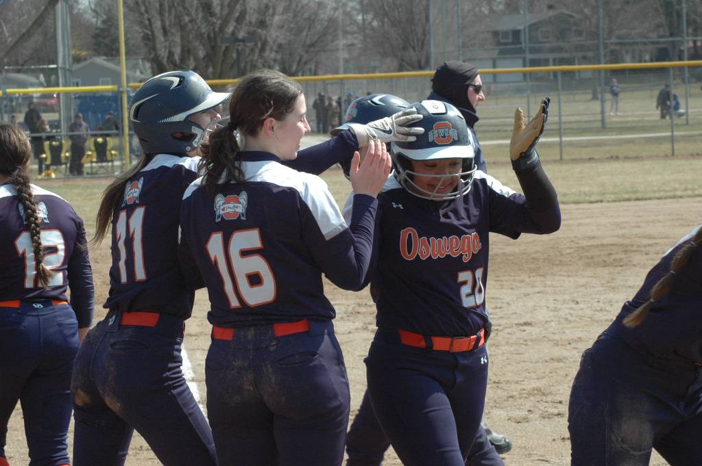 Oswego's Jaelyn Anthony receives congratulations from teammates Kaylee LaChapell (11) and Rikka Ludvigson (16) on her home run during a nonconference game at Geneva on Thursday, March 30, 2023.