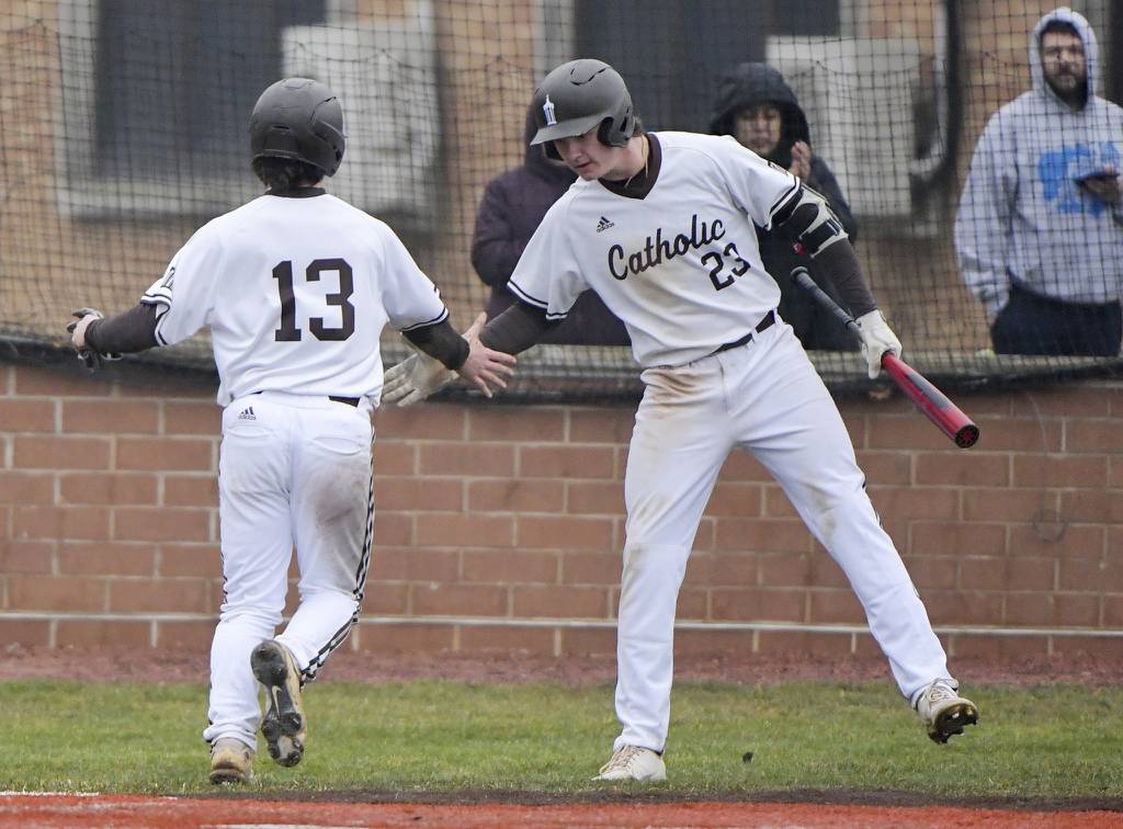 Joliet Catholic's Brett Hulbert (13) and Trey Swiderski (23) celebrate after scoring a run against Brother Rice during a nonconference game in Joliet on Wednesday, March 22, 2023.
