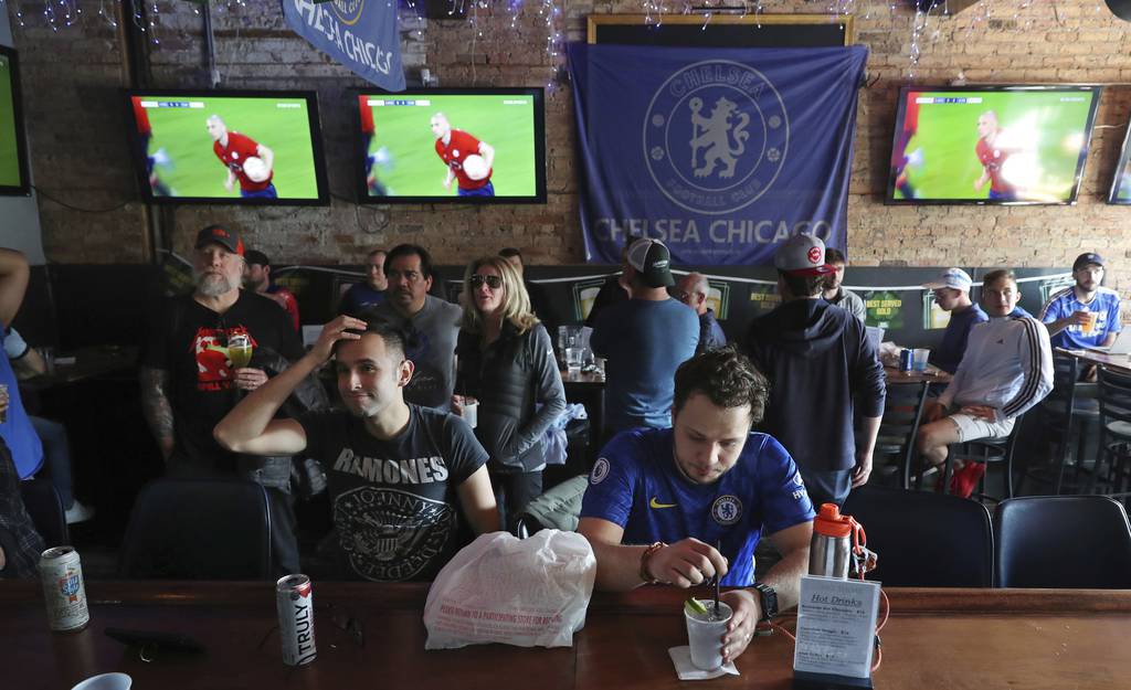 Fans watch a Champions League match between Chelsea Football Club and Lille Olympique Sporting Club on television at Graystone Tavern on March 16, 2022, in Chicago.