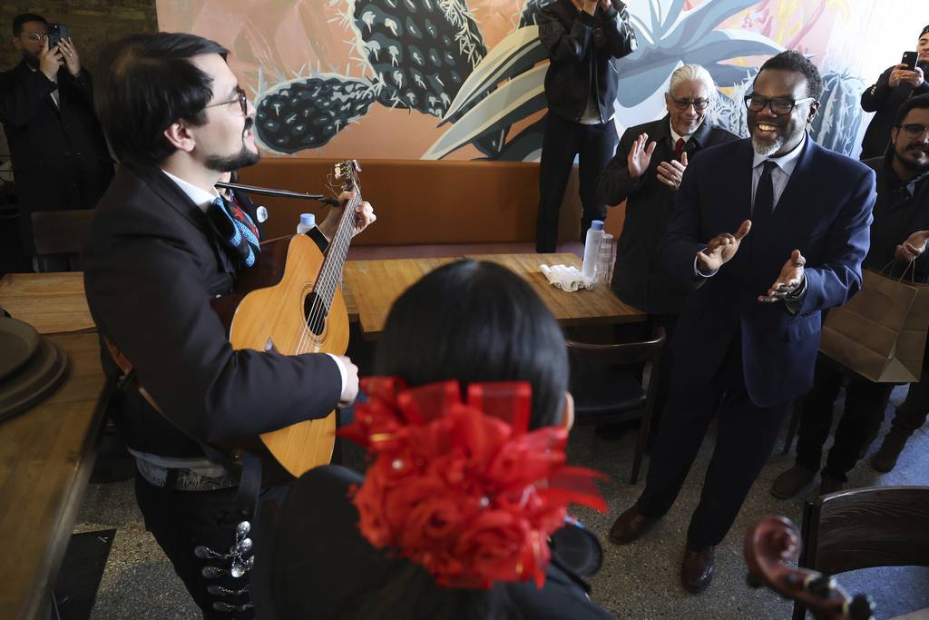 While campaigning in stores along the 18th Street corridor in Chicago’s Pilsen neighborhood, Chicago mayoral candidate Brandon Johnson, right, is serenaded by the band Mariachi Estrellas de Chicago at the restaurant Pochos on March 27, 2023, which is Johnson’s birthday. 