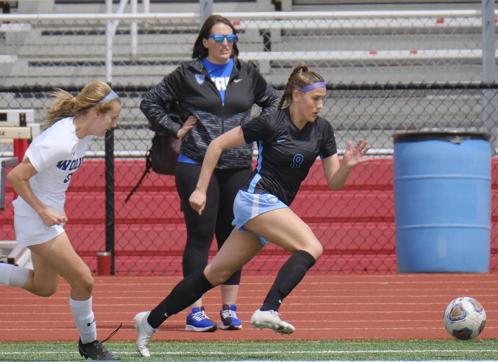 St. Charles North's Sophia Hein (8) advances the ball as Oswego East's Anya Gulbrandsen gives chase during a Naperville Invitational game on Saturday, April 23, 2022.