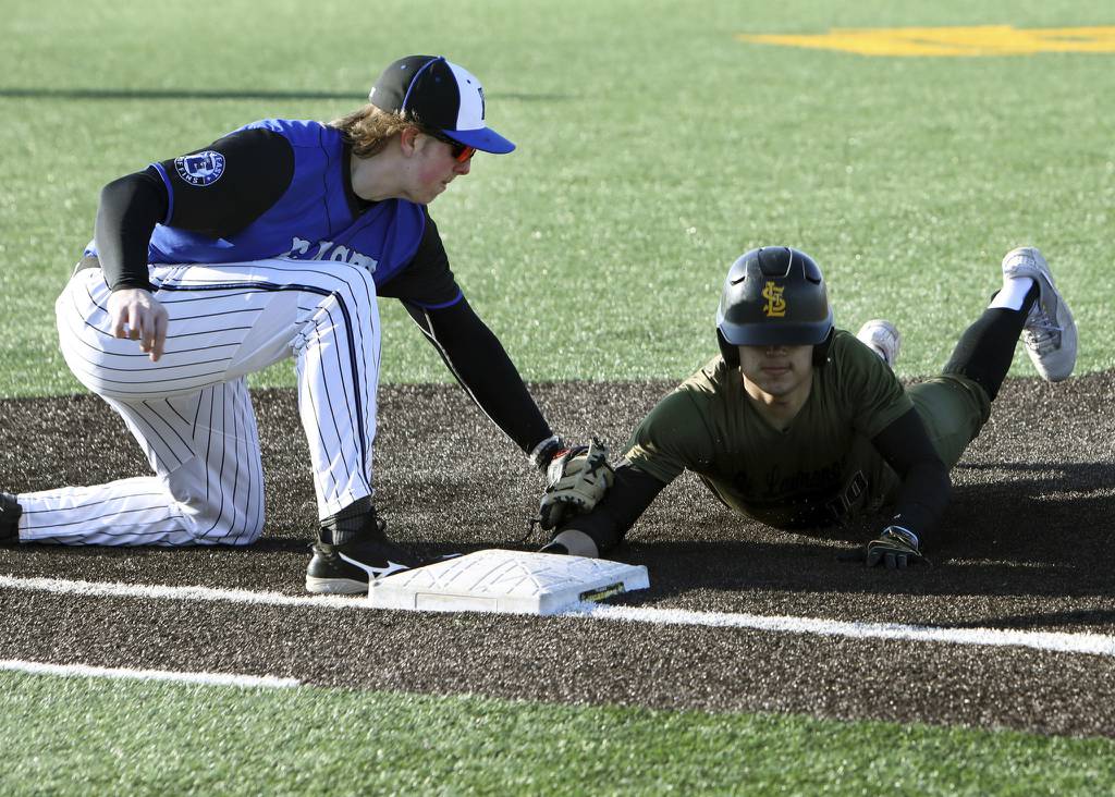Lincoln-Way East's John Connors tags out St. Laurence's Richard Gomez during a nonconference game in Burbank on Wednesday, March 29, 2023.