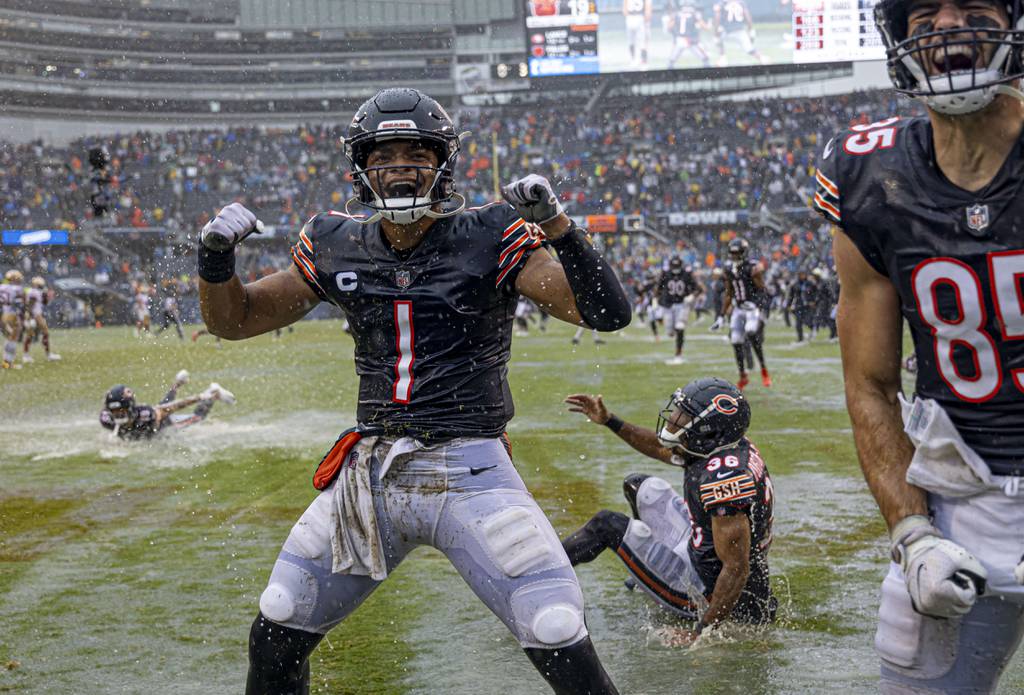 Bears quarterback Justin Fields and teammates celebrate the season-opening win over the 49ers by sliding into end-zone puddles on Sept. 11, 2022, at Soldier Field.