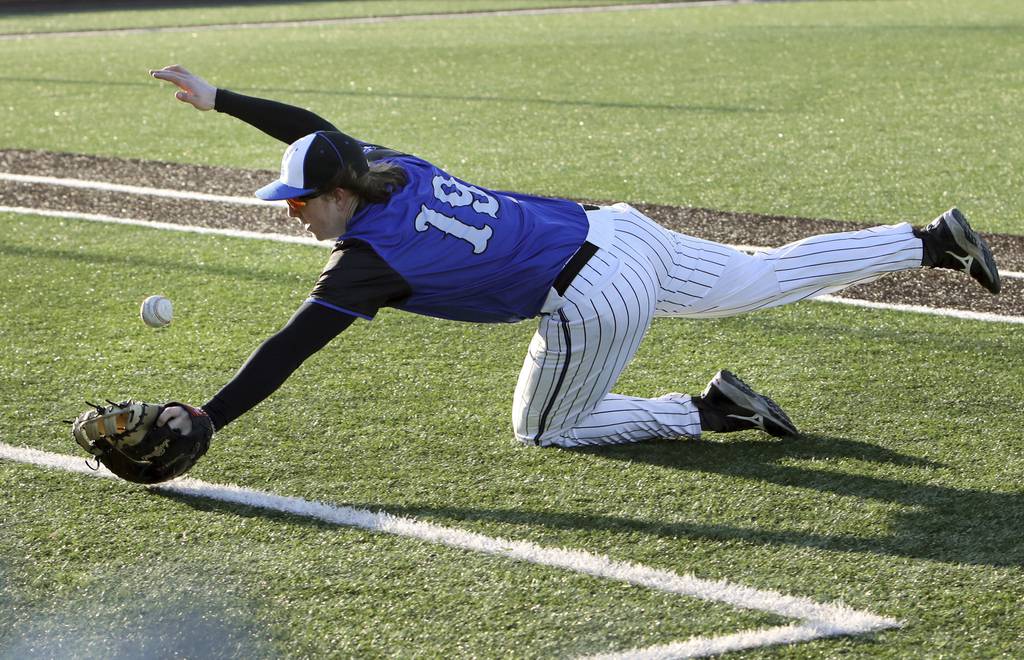 Lincoln-Way East's John Connors dives for a foul ball against St. Laurence during a nonconference game in Burbank on Wednesday, March 29, 2023.
