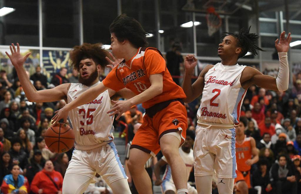 Brother Rice's Cale Cosme (10) makes a pass around Kenwood's Solomon Mosley (35) during the Class 4A St. Rita Sectional championship game in Chicago on Friday, March 3, 2023.