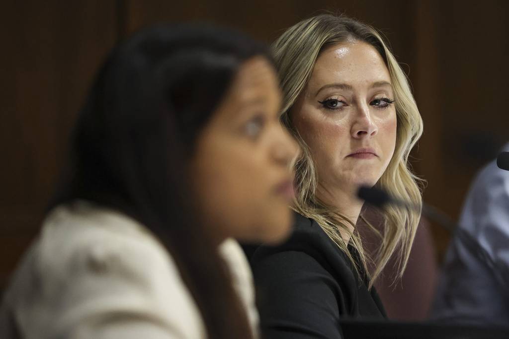 School board candidate Amanda “Amy” Erkenswick listens to her competitor Anjali Bharadwa speak during a District 200 school board candidate forum on March 2, 2023, in Wheaton.  